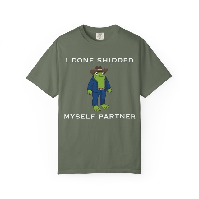 Graphic tee with a cartoon frog standing on its hind legs wearing a denim coat, jeans, belt buckle, and a cowboy hat with text surrounding it saying: "I done shidded myself partner". Front view, color green.